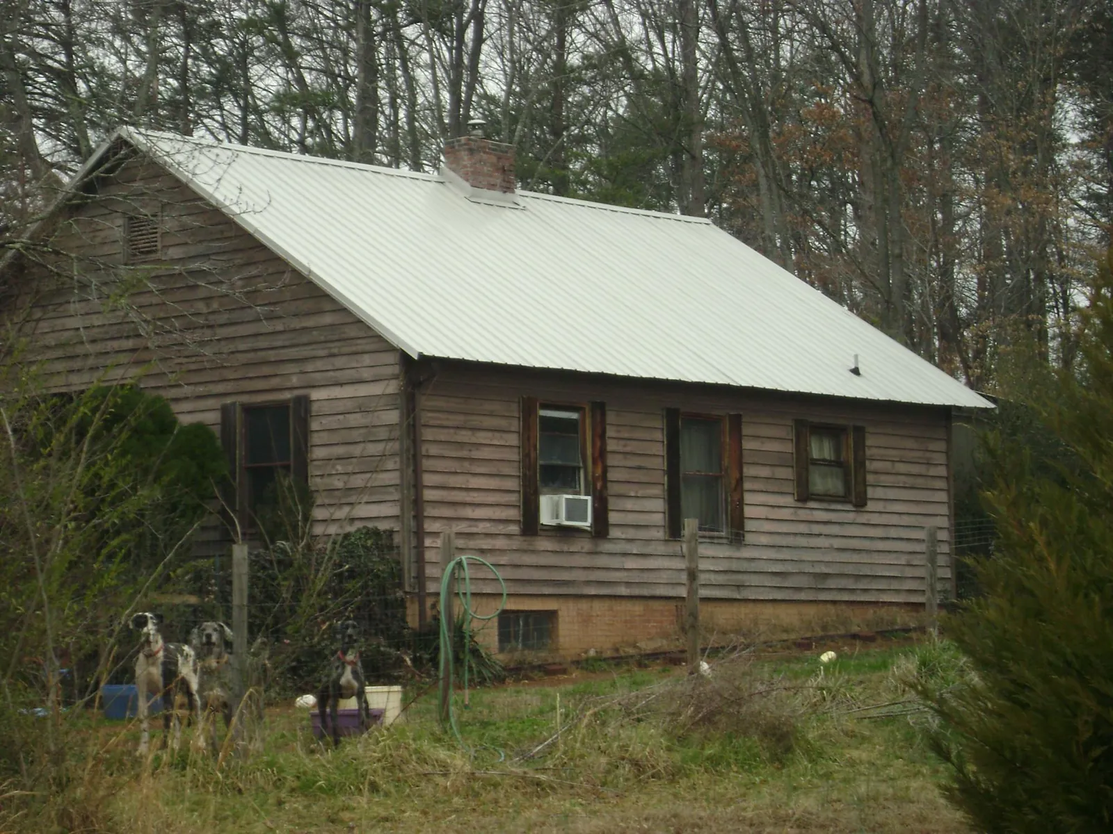 White metal roof on an old wood sided farmhouse, from a Metal Roof Installation job in Milroy